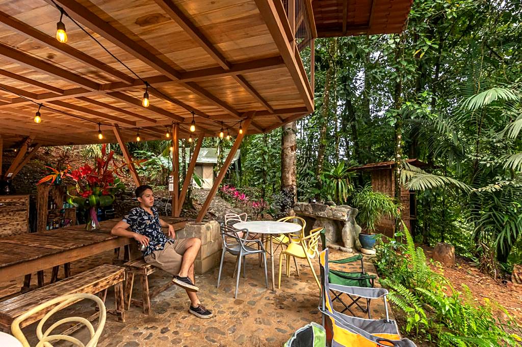 A guest sitting in the dining area under the wooden roof