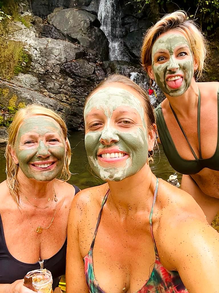 Guests with clay masks by the waterfall