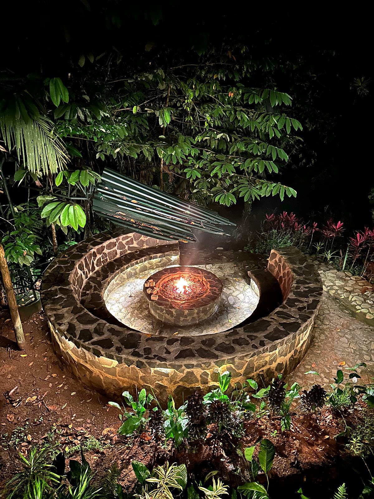 The stone fire pit lit at night