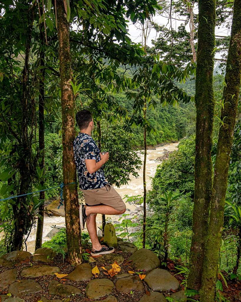 Guest leaning on a tree above the river