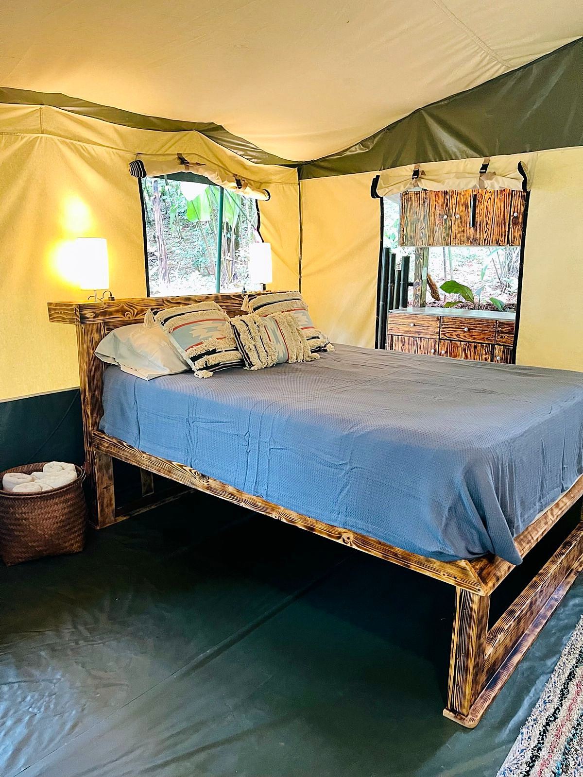 Double bed with a blue cover in the large tent