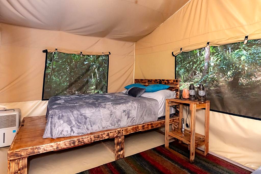 Double bed in a safari tent with views of the forest