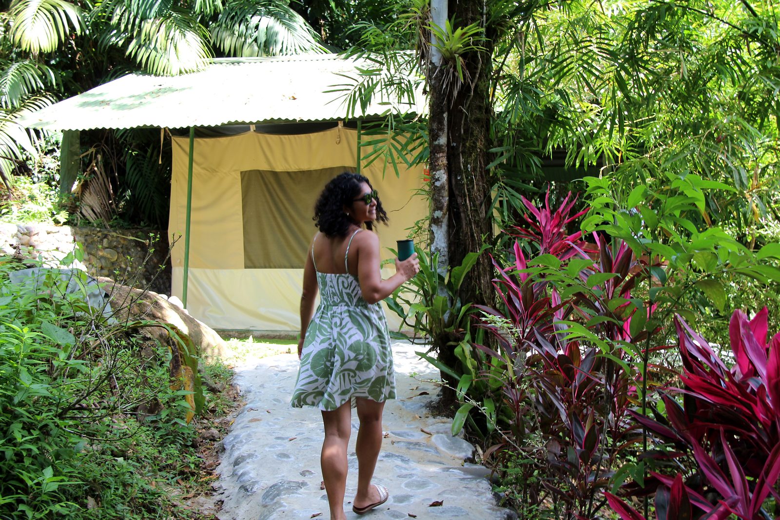 A woman walking the garden path to the Standard tent
