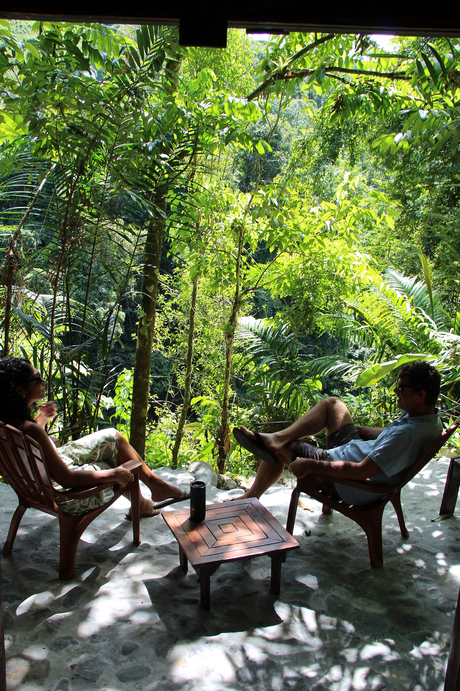 Two people at the low table on the shaded terrace